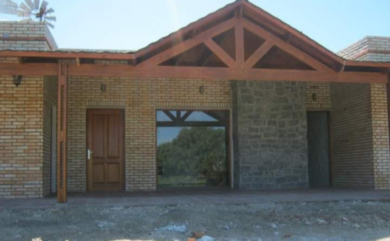Casa con fachada de ladrillo, piedra y estructura de madera